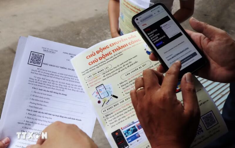 Hộ kinh doanh cài đặt phần mềm eTax Mobile tự kê khai thuế. (Ảnh: Thu Hiền/TTXVN)